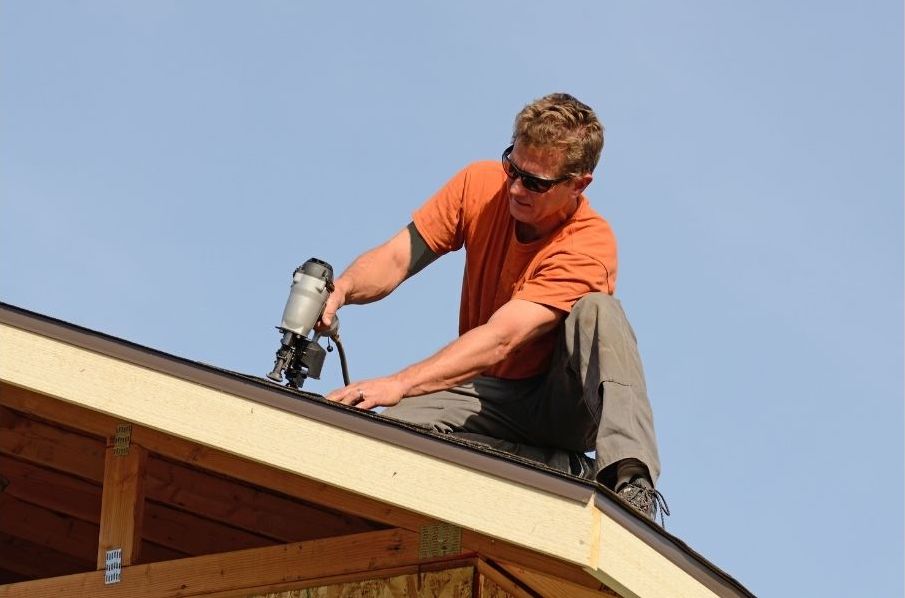 Roofer securing surface of roof.